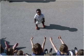 Kinder auf einem Hof: ein Kind steht allein, andere strecken die Arme entgegen